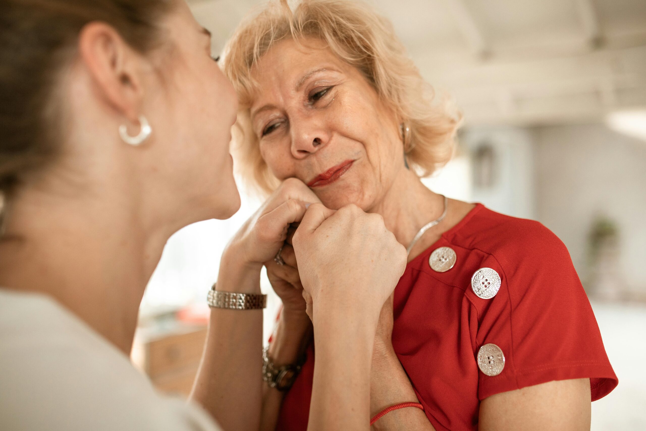 A touching scene showing affectionate connection between two women indoors.