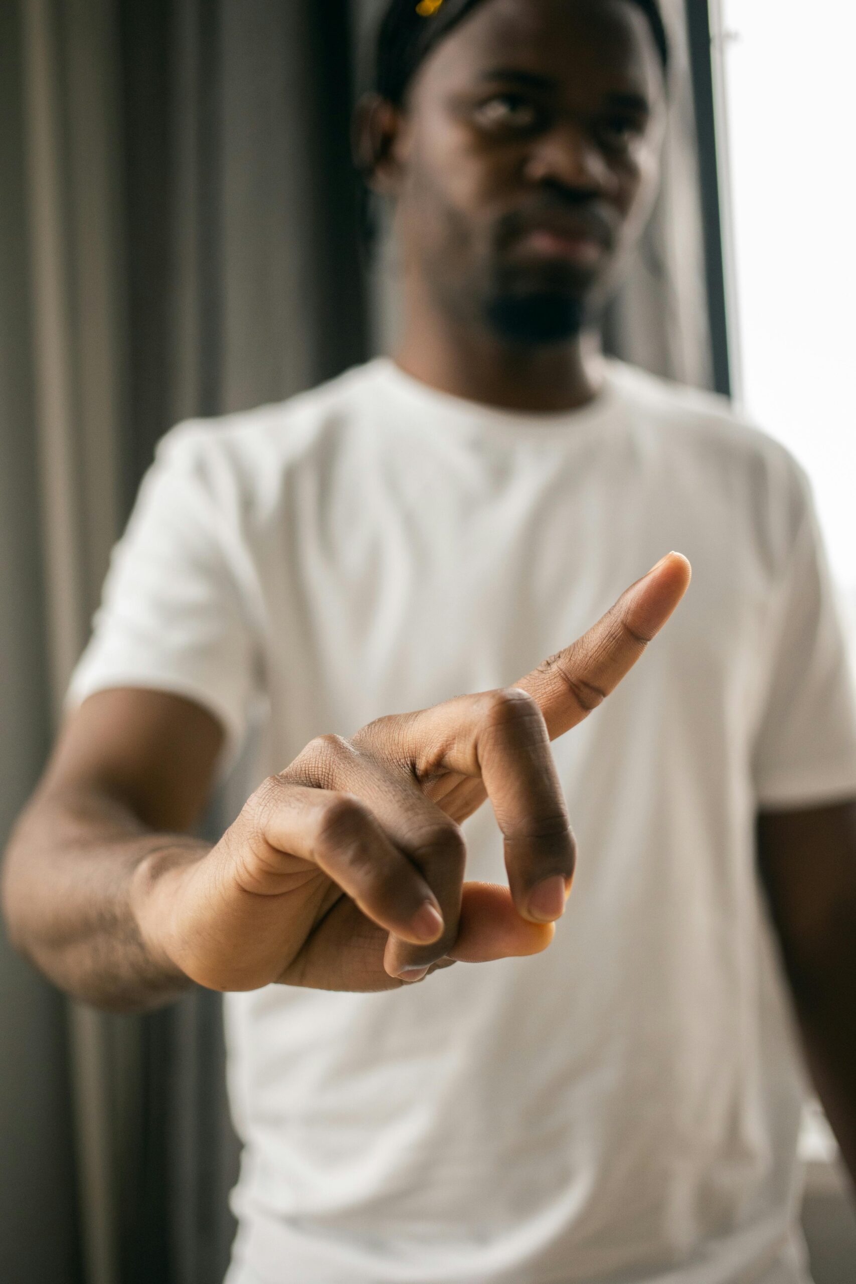 A serious man inside raising his index finger in a gesture of disapproval or restriction.